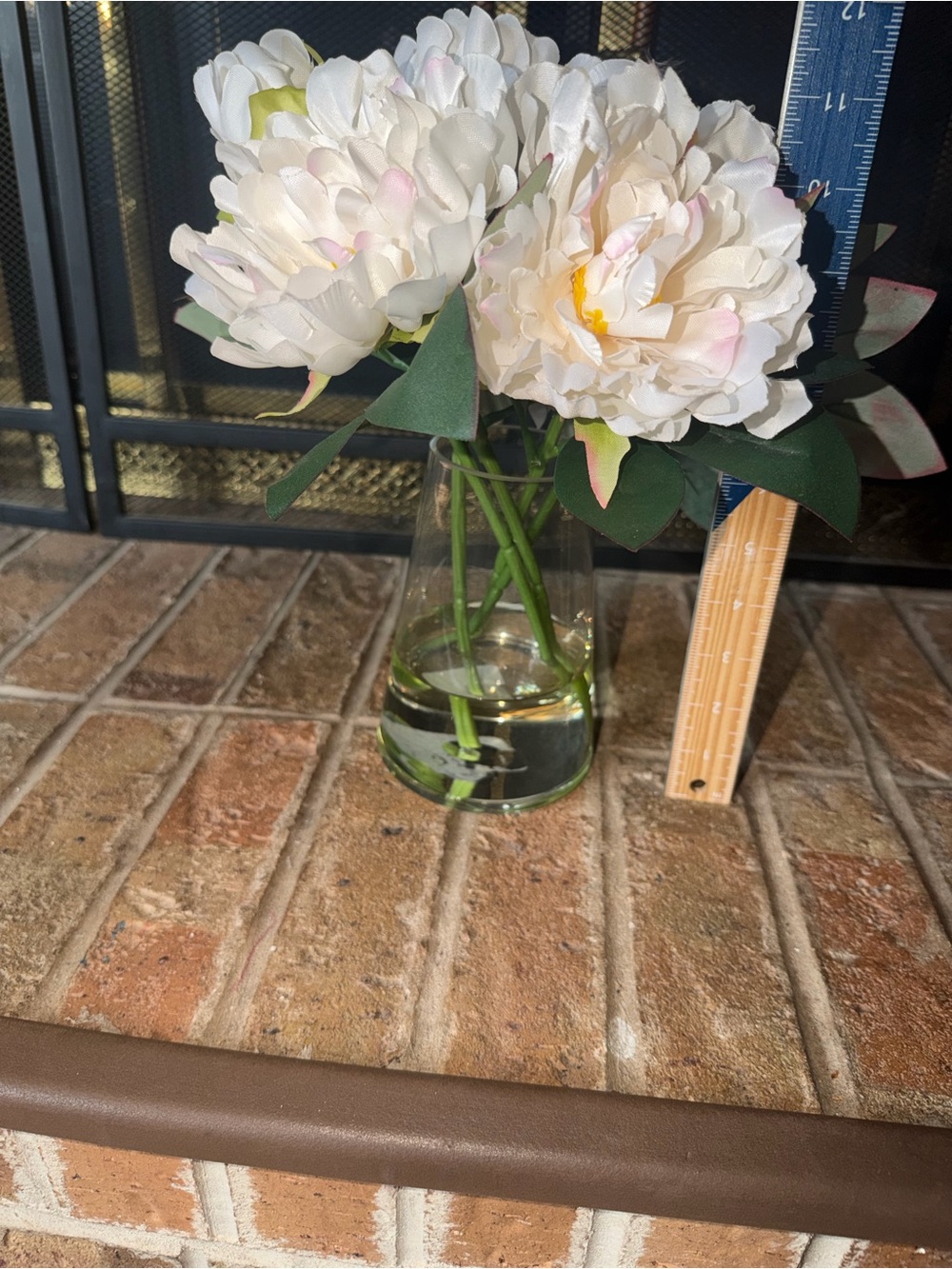 11” cute white bouquet flowers anchored in glass vase
